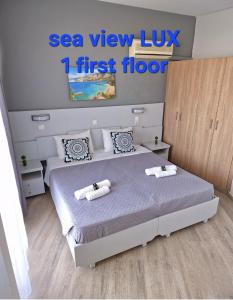 1 dormitorio con 1 cama con 2 toallas en BLUE EYES APARTMENTS en Ixia