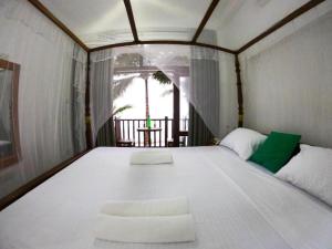 1 cama blanca grande en una habitación con ventana en Asa Bay Beach Resort, en Talpe