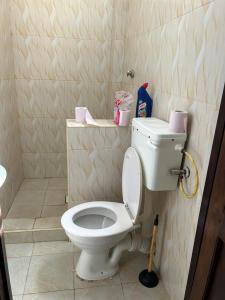 a bathroom with a white toilet in a room at Cozy Holiday Homes. in Ukunda