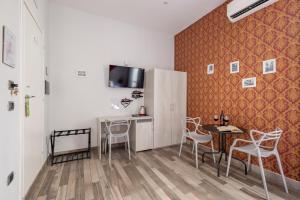 a kitchen with a table and chairs and a refrigerator at Scaramantico Rooms in Naples