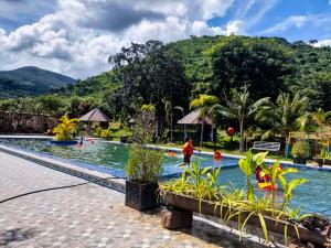 a resort swimming pool with a mountain in the background at Kampot Hill Lodge in Kampot