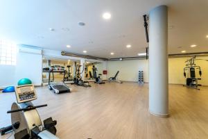 a gym with several treadmills and machines in a room at Oceanis Hotel in Kavála