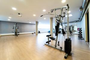 a gym with treadmills and exercise equipment in a room at Oceanis Hotel in Kavála