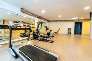 a gym with treadmills and exercise bikes in it at Oceanis Hotel in Kavála