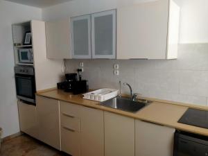 a kitchen with white cabinets and a sink at Espace et sérénité in Netanya