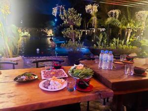 a wooden table with plates of food on it at Kampot Hill Lodge in Kampot