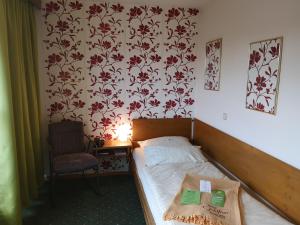 1 dormitorio pequeño con 1 cama y 1 silla en Hotel Goldflair am Rathaus, en Korbach