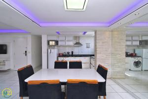 a kitchen with a table and chairs in a room at Moderno Apto 3 suites p/ 8 pessoas em Copacabana in Rio de Janeiro