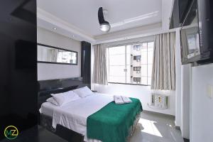 1 dormitorio con 1 cama con manta verde en Moderno Apto 3 suites p/ 8 pessoas em Copacabana, en Río de Janeiro