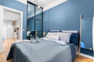 a bedroom with a large bed with blue walls at Modern apartment - Luxury neighborhood - 4 pax in Oslo