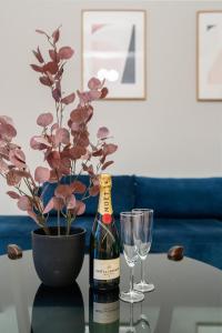 a bottle of wine on a table with a potted plant and glasses at Modern apartment - Luxury neighborhood - 4 pax in Oslo