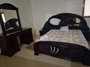 a bedroom with a bed and a dresser and a mirror at Monteiro Paradise Guest House in São Tomé