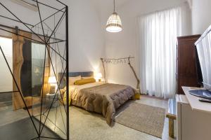 1 dormitorio con 1 cama y pared de cristal en Dongiovanni Suite, en Lecce