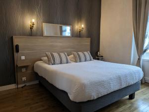 1 dormitorio con 1 cama grande y cabecero de madera en Logis Hôtel Le Saint Florent, en Mont-près-Chambord