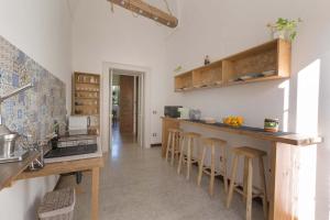 a kitchen with a counter and bar stools at Dongiovanni Suite in Lecce