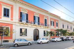 a building with cars parked in front of it at Dongiovanni Suite in Lecce