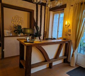 a wooden desk in a room with a window at Logis Hôtel Le Saint Florent in Mont-près-Chambord