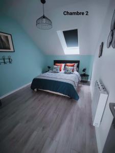 a bedroom with a bed and a wooden floor at Maison avec Borne de recharge in Rolampont