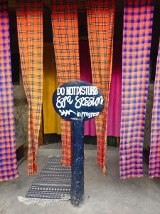 a do not disturb sign on a pole in front of curtains at Lillypond Camp in Elmenteita