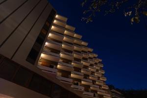 a tall building with many windows at night at Oceanis Hotel in Kavála