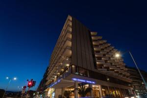 a tall building on a city street at night at Oceanis Hotel in Kavála