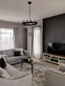 a living room with two couches and a television at Swara Ranch Nanyuki in Nanyuki