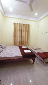 a room with two beds and a window in it at ARJUN PAYING GUEST HOUSE in Ayodhya