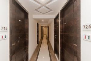OYO Flagship Hotel Park Palace في مومباي: ممر في مبنى بأبواب خشبية