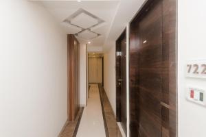 a hallway with a wooden wall and a door at OYO Flagship Hotel Park Palace in Mumbai