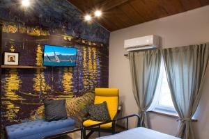 a room with a wall with a tv and a couch at La casetta di Francy, Medea in Medea