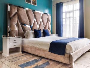 a bedroom with a large bed with a large headboard at Swara Ranch Nanyuki in Nanyuki