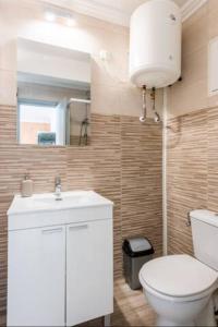 een badkamer met een toilet, een wastafel en een spiegel bij Pedro Happy Studios in Torremolinos