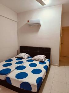 a bed with a blue and white comforter in a room at The Trails Kampar in Kampong Malim Nawar