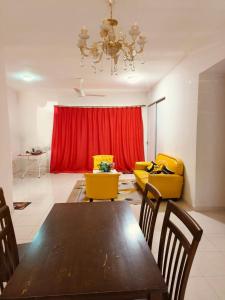 a living room with a table and a red curtain at The Trails Kampar in Kampong Malim Nawar