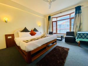 um quarto de hotel com uma cama e uma grande janela em Hotel Hamta View Manali !! Top Rated & Most Awarded Property in Manali !! em Manali