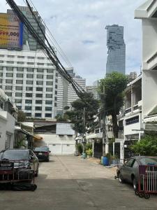 a city street with cars parked in front of buildings at The Cute Silom hostel in Bangkok