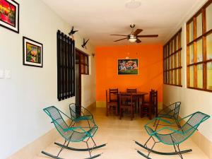 uma sala de jantar com cadeiras e uma parede laranja em Sauce Suites - em Sauce
