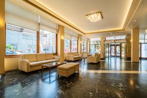 a lobby with couches and tables in a building at Oceanis Hotel in Kavála