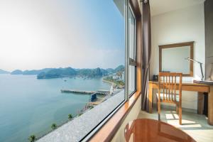 a room with a desk and a view of the water at Cat Ba Paradise Hotel- Pool & Sky Bar in Cat Ba