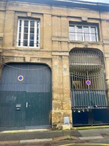 two garage doors on a brick building with windows at Saint François in Bordeaux