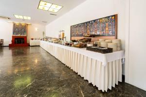 a restaurant with a long counter in a room at Oceanis Hotel in Kavála