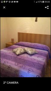 Un dormitorio con una cama morada con sábanas moradas. en San Pietro, en Mileto