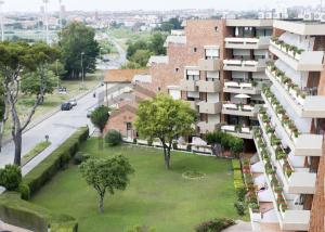 リヴォルノにあるSuites Marilia Apartments - Suite Livorno Holiday Home Groupの緑の芝生が目の前に広がるアパートメントビル