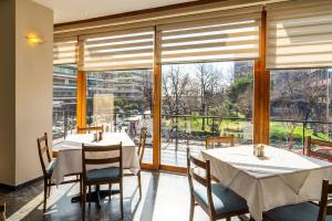 a dining room with two tables and a large window at Oceanis Hotel in Kavála