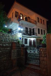 Un grand bâtiment blanc avec balcon est disponible la nuit. dans l'établissement Villa Dudinka, à Ohrid