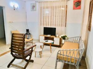 sala de estar con escritorio, sillas y TV en Point vert, en Kribi