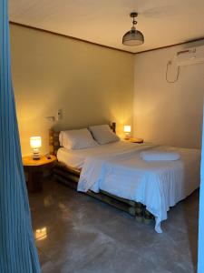 a bedroom with a bed with two lamps on it at Point vert in Kribi