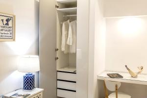 a white closet with a desk and a lamp at Gheba Suites in Sorrento