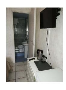 eine Küche mit einem Kühlschrank, einer Spüle und einem TV in der Unterkunft B & B AMICI DELL'ETNA in Nicolosi