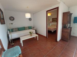 ein Wohnzimmer mit einer Couch und einem Spiegel in der Unterkunft Apartamento en Villa con Piscina in Málaga + 34 Fotos